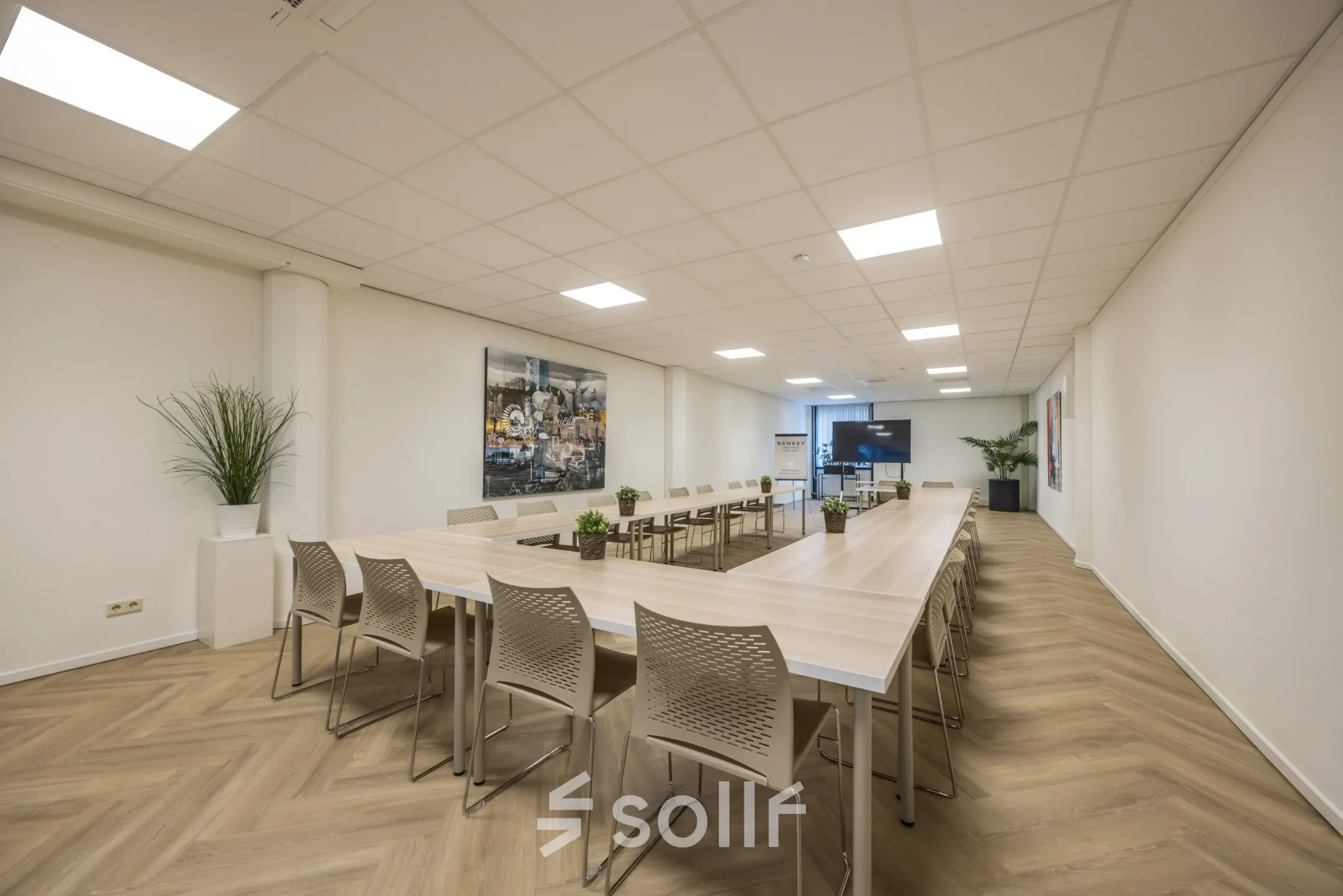 Ruime en lichte kantoorruimte met een grote tafel en stoelen, ideaal voor vergaderingen of samenwerking. De ruimte bevindt zich op Luchthavenweg 81, perfect voor kantoorruimte huren op Eindhoven Airport.