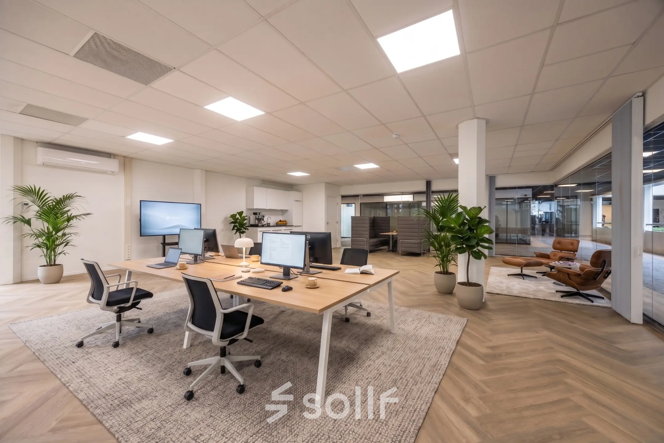 Ruime en moderne kantoorruimte met open werkplekken en comfortabele stoelen bij Eindhoven Airport, perfect voor wie op zoek is naar kantoorruimte huren. Strakke inrichting en veel natuurlijk licht.
