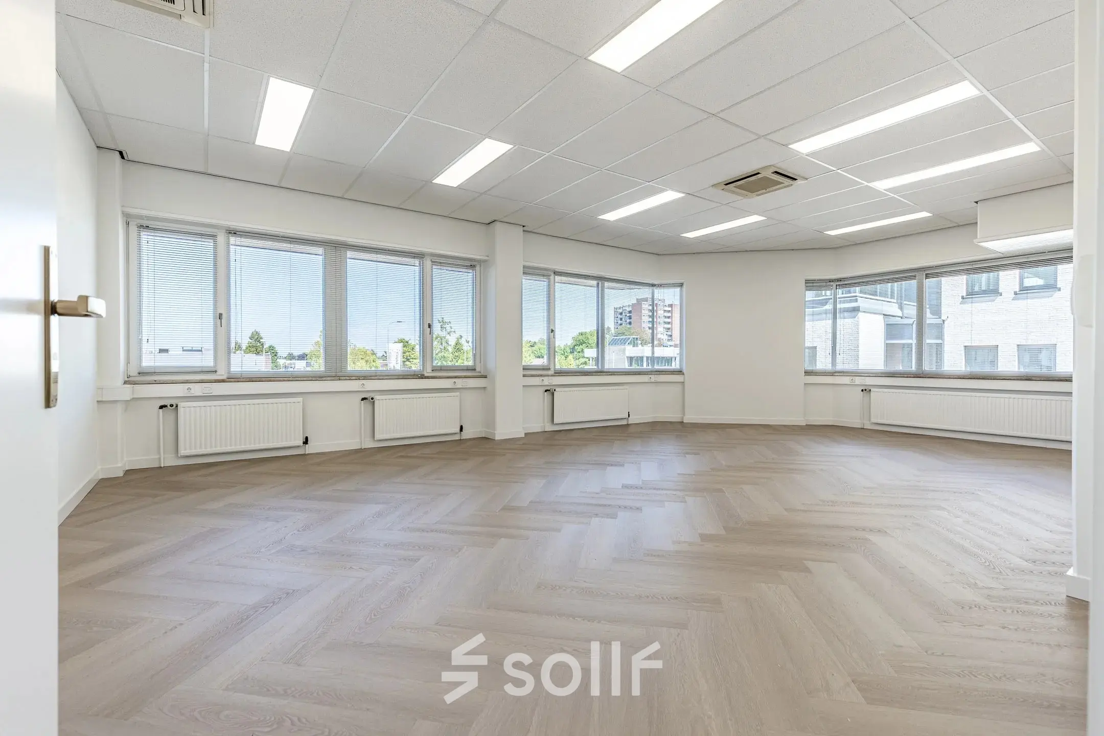 Ruime, lichte kantoorruimte met grote ramen en een visgraatvloer, ideaal voor huren in een kantoorpand op Croy 7, Eindhoven De Hurk.
