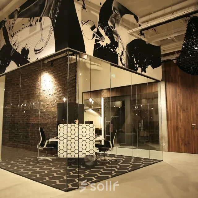 Modern kantoorpand op Frederiklaan 10E, Eindhoven Strijp-S, met glazen wanden en stijlvolle inrichting. Geschikt voor kantoorruimte huren. Sfeervolle verlichting en decoratieve elementen geven de ruimte een professionele uitstraling.