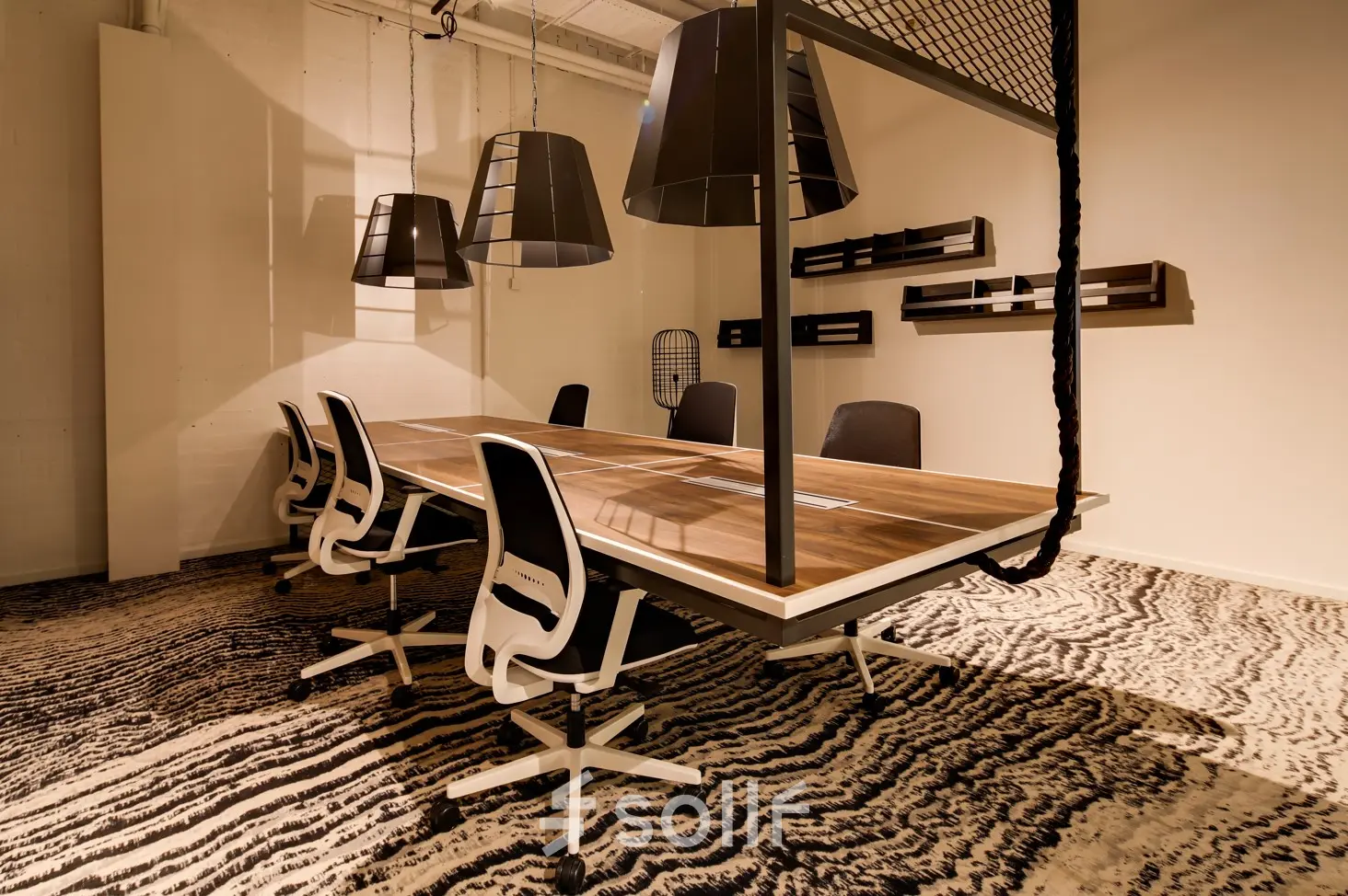 Moderne kantoorruimte met grote houten tafel, designstoelen en stijlvolle verlichting. Ideaal voor vergaderen of als flexibele werkplek. Gelegen op Frederiklaan 10E, Eindhoven Strijp-S, klaar voor verhuur.