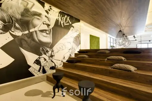 Unieke kantoorruimte huren in Eindhoven Strijp-S op Frederiklaan 10E, met houten trappen en kleurrijke muurschilderingen. Ideale plek voor creatieve bijeenkomsten.