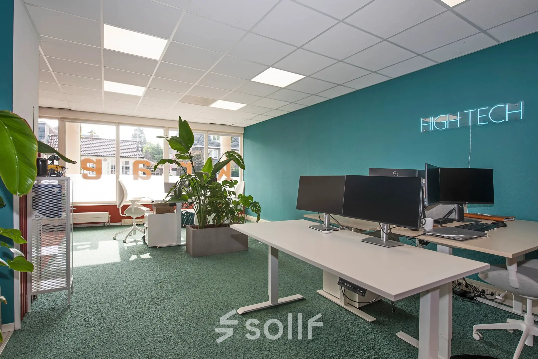 Moderne kantoorruimte op Boddenkampsingel 95 in Enschede met groen tapijt, bureaus met computers en planten. Geschikt voor huur als werkplek in een kantoorpand.