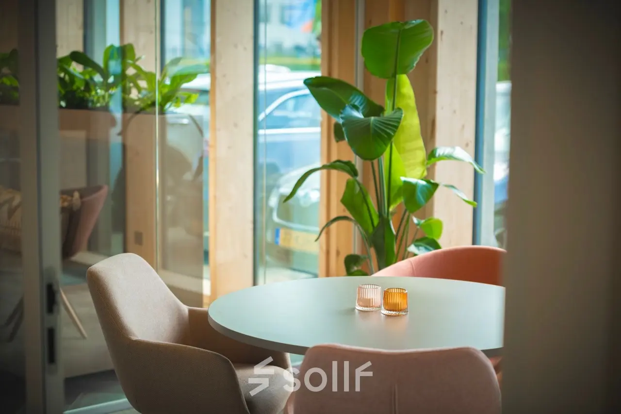 Moderne kantoorruimte huren aan Moutlaan 1-23, Enschede met stijlvolle ronde tafel, comfortabele stoelen en groen decor voor een inspirerende werkervaring.