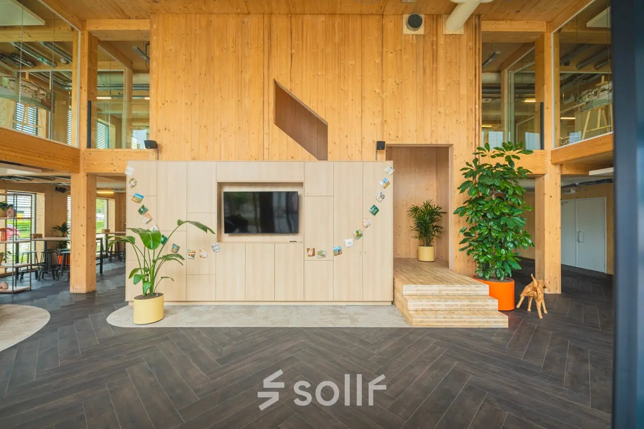 Moderne en uitnodigende kantoorruimte op Moutlaan 1-23, Enschede met houten wanden, veel groen en een tv-wand, perfect om te huren als inspirerend kantoorpand.
