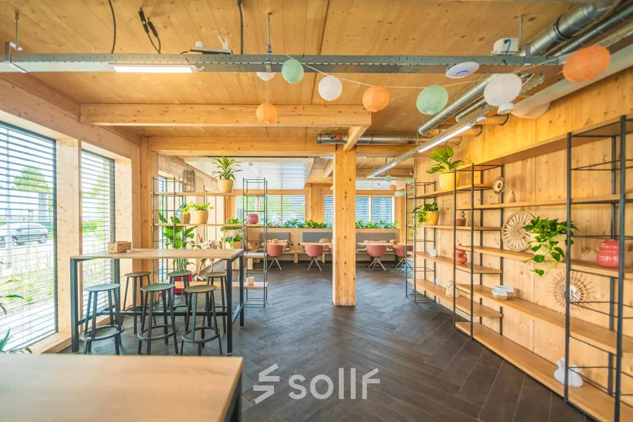 Lichte kantoorruimte huren op Moutlaan 1-23 in Enschede met een moderne, warme uitstraling, houten accenten en speelse decoratie. Ideaal voor flexibele werkplekken in een inspirerende omgeving.