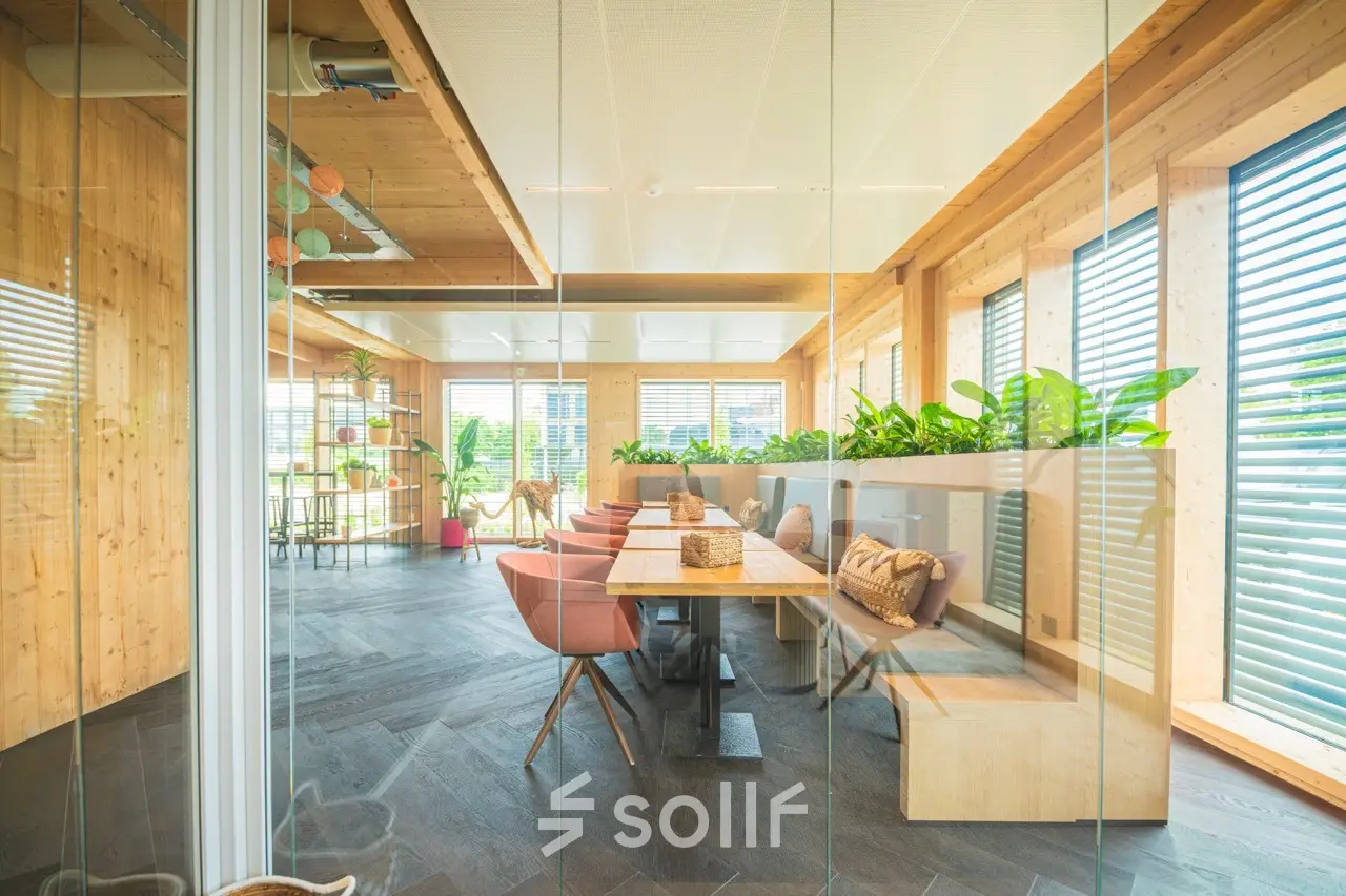Licht en modern ingerichte kantoorruimte met houten accenten en planten aan Moutlaan 1-23, Enschede. Ideaal voor wie op zoek is naar een inspirerend kantoor om te huren.