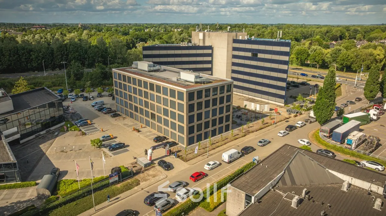 Buitenzicht van een modern kantoorpand op Moutlaan 1-23 in Enschede, ideaal voor bedrijven die kantoorruimte willen huren. Het gebouw is omgeven door voldoende parkeergelegenheid.