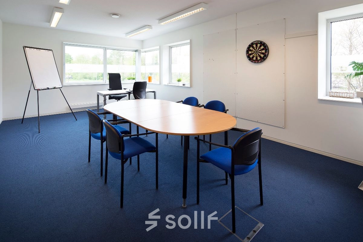 Kantoorruimte huren aan de Transportlaan 1-151 in Geleen, met vergadertafel, stoelen en een flipover in een lichte kamer.
