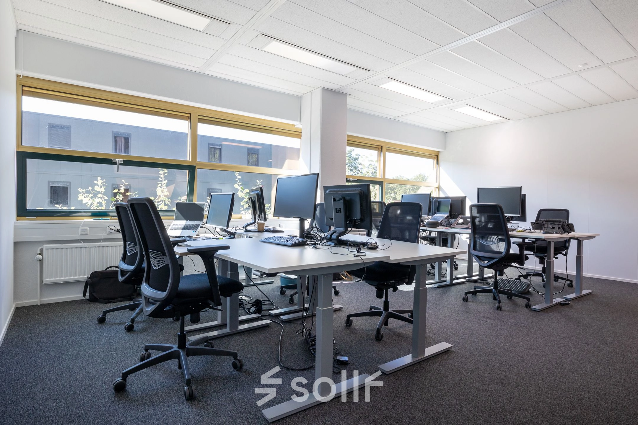 Lichte kantoorruimte in Gouda aan Groningenweg 8 8 met diverse bureaus en stoelen, ideaal voor kantoor huren. Grote ramen zorgen voor veel natuurlijk licht.