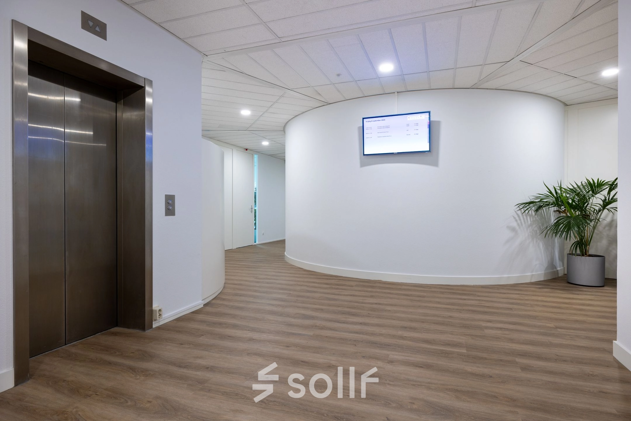 Ruime, lichte entree van een kantoorpand op Groningenweg 8 8 in Gouda met een moderne houten vloer, strakke witte muren en een lift. Ideaal voor kantoorruimte huren.