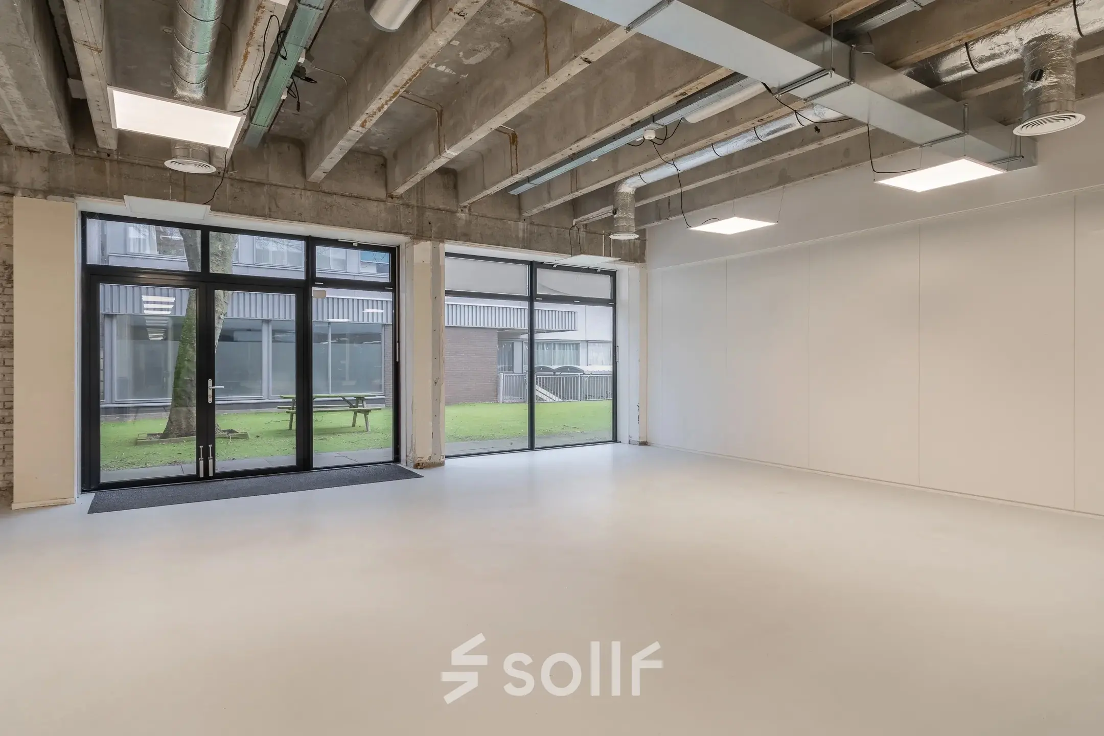 Ruime kantoorruimte te huur met grote ramen en zicht op groene buitenruimte aan de A. Hofmanweg 5A, Haarlem Waarderpolder. Ideaal voor creatieve kantoren met een industriële uitstraling.