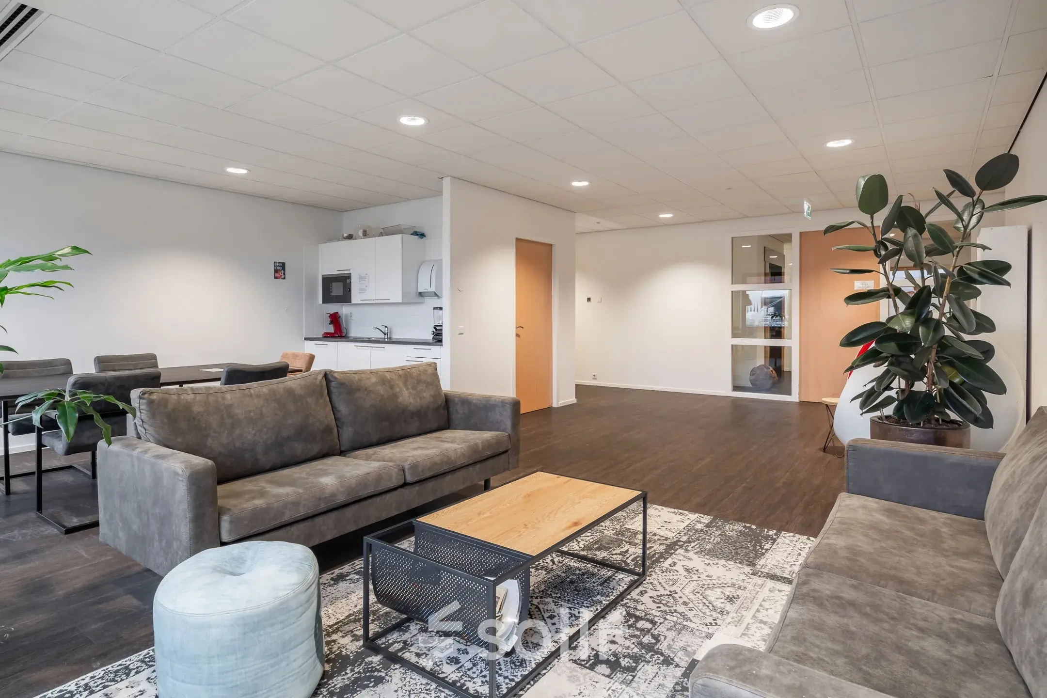 Ruime kantoorpand op Mollerusweg 84 in Haarlem Waarderpolder, met moderne zitbanken, een stijlvolle tafel, en een kleine keukenhoek. Ideale kantoorruimte huren voor informele vergaderingen of ontspanning.