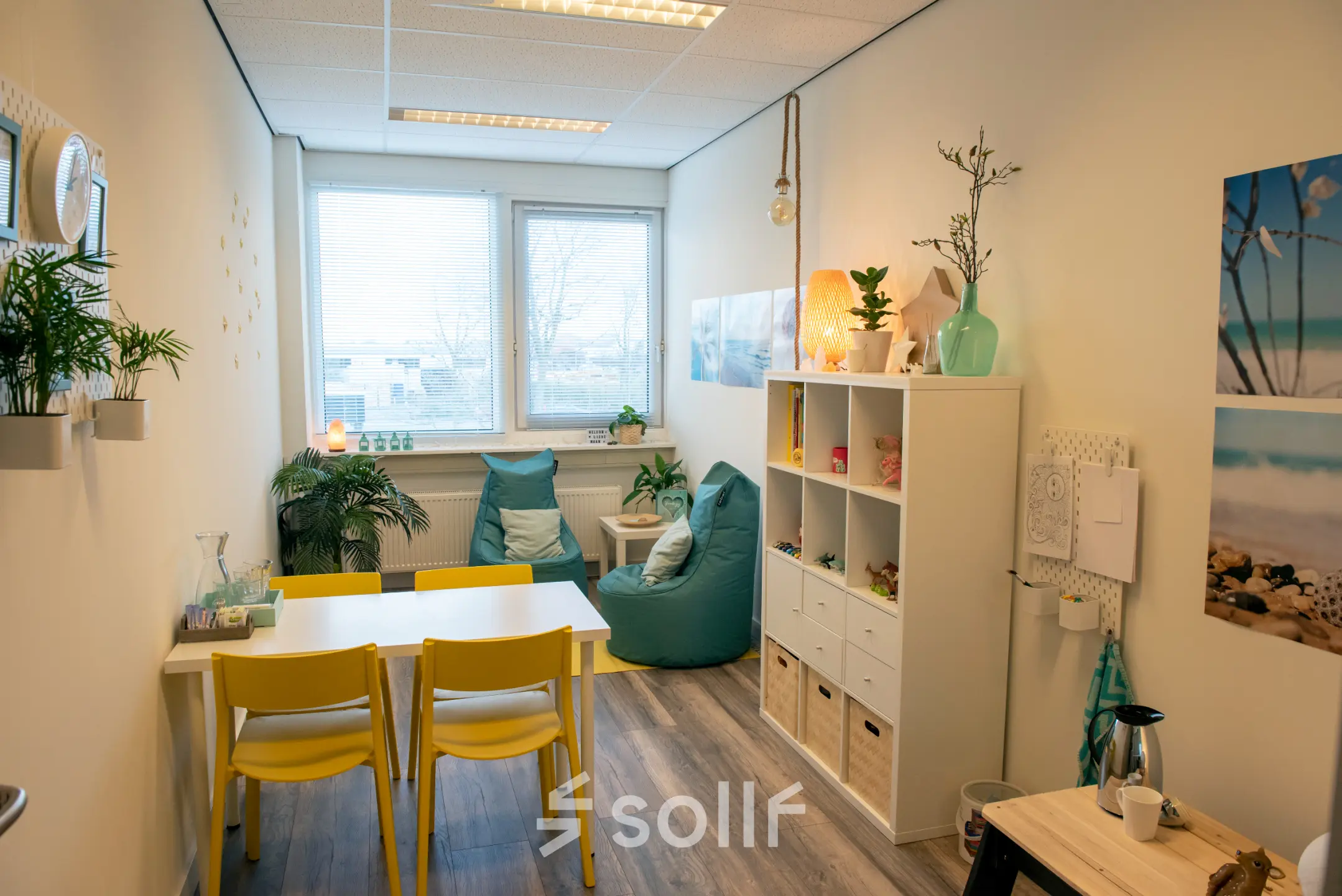 Gemeubileerde kantoorruimte te huur op Waarderweg 19 in Haarlem Waarderpolder, met een kleine tafel, felgekleurde stoelen en decoratieve elementen.