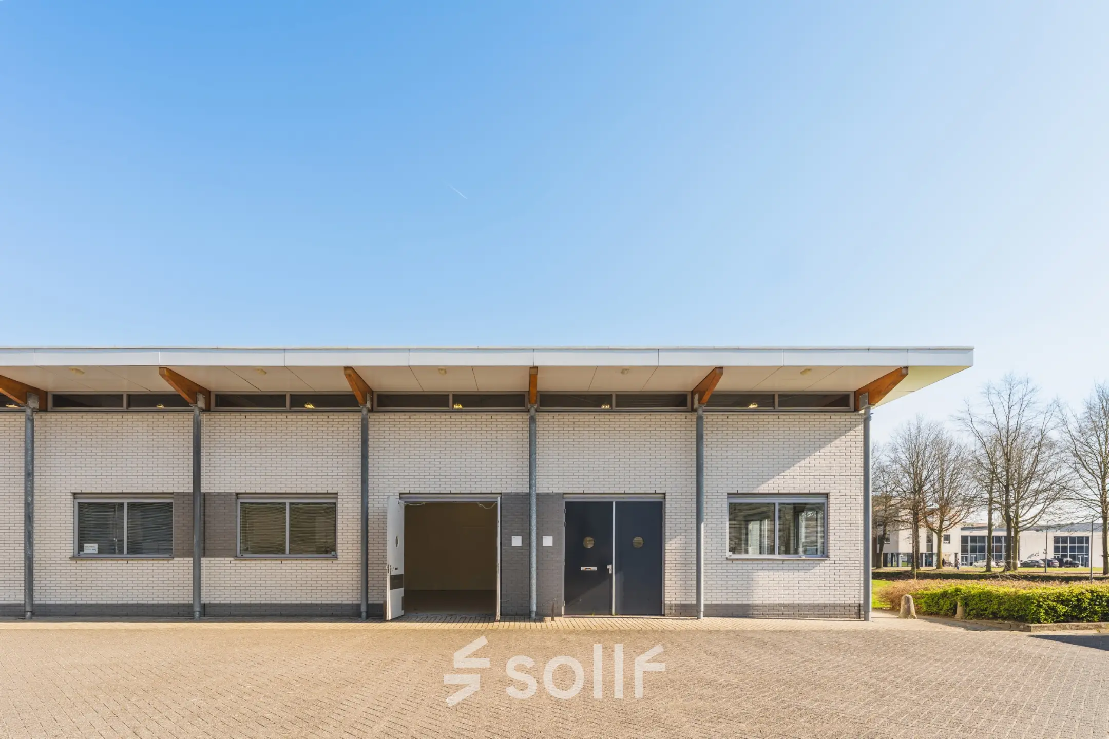 Exterieur van een kantoorpand op Steenovenweg 5 in Helmond, geschikt voor kantoorruimte huren. Bakstenen gevel met moderne ramen en een inrit.