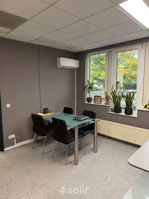 Lichte kantoorruimte op Hamerstraat 10 in Hengelo, met glazen tafel, vijf stoelen en planten voor het raam. Ideaal voor kantoorruimte huren.