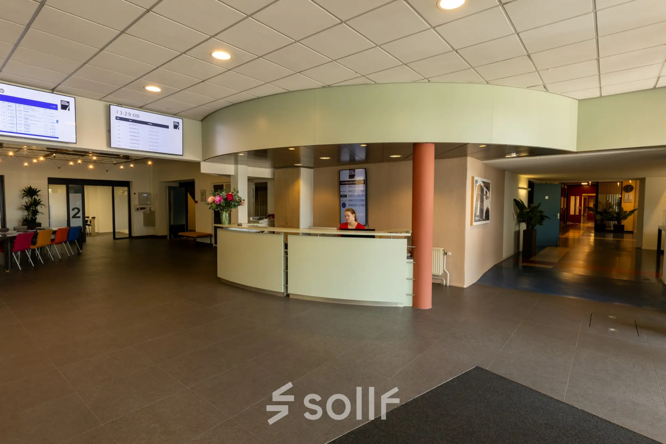 Ontvangstruimte in een kantoorpand op Lansinkesweg 4, Hengelo met een balie en kleurrijke stoelen. Perfect voor kantoorruimte huren, met een gastvrije sfeer.