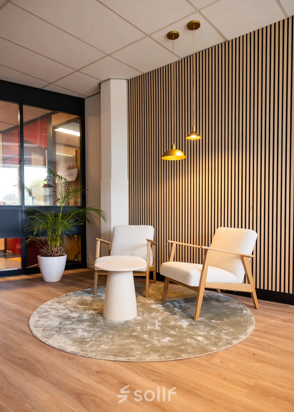 Gezellige kantoorruimte huren in Hengelo met moderne stoelen en stijlvolle houten wandbekleding, ideaal voor informele ontmoetingen of pauzes.