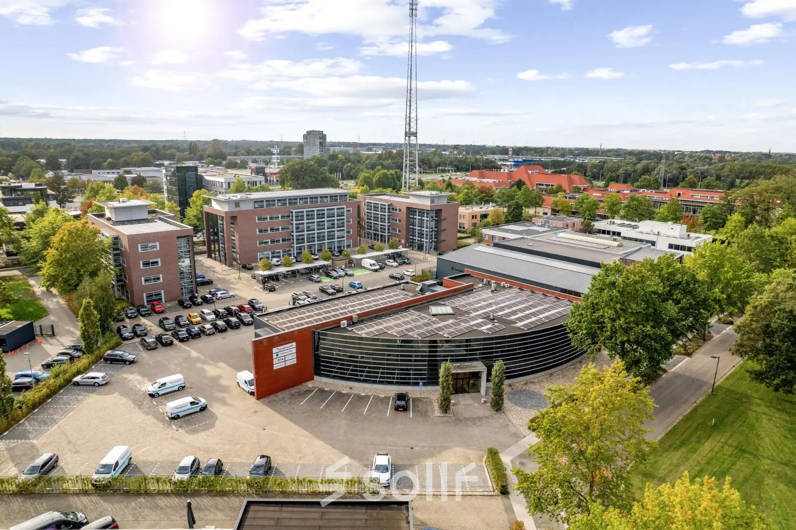 Luchtfoto van het kantoorpand op Lintelerweg 40 in Hengelo, omgeven door parkeerplaatsen en groene bomen. Ideale locatie voor kantoorruimte huren in een levendige omgeving.