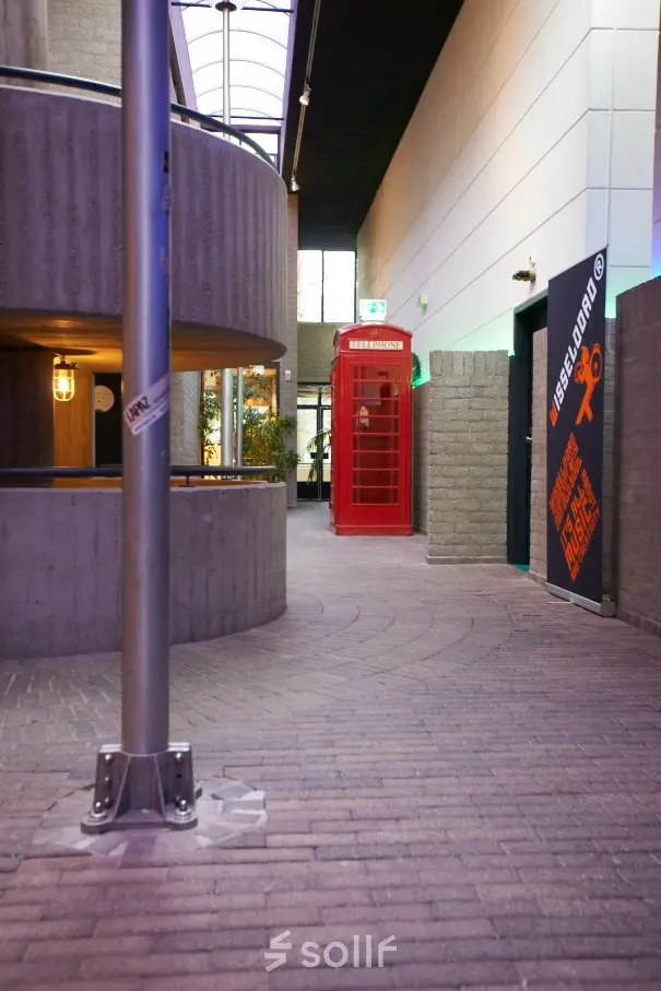 Binnenkant van kantoorpand op Catharina van Renneslaan 8-10, Hilversum, met een rode telefooncel als decoratief element en moderne betonnen elementen. Ideaal voor kantoorruimte huren.