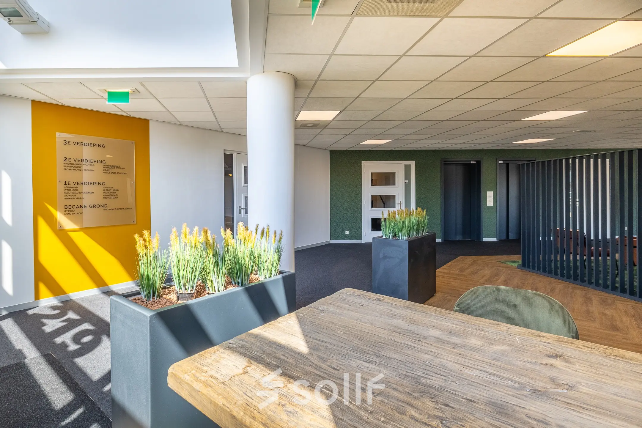 Lichte kantooruimte te huur met stijlvol houten tafel, moderne plantenbakken en zitgedeeltes. Ideaal kantoorpand in Hilversum voor vergaderingen en creatieve brainstorms. Strategisch gelegen op Franciscusweg 219.