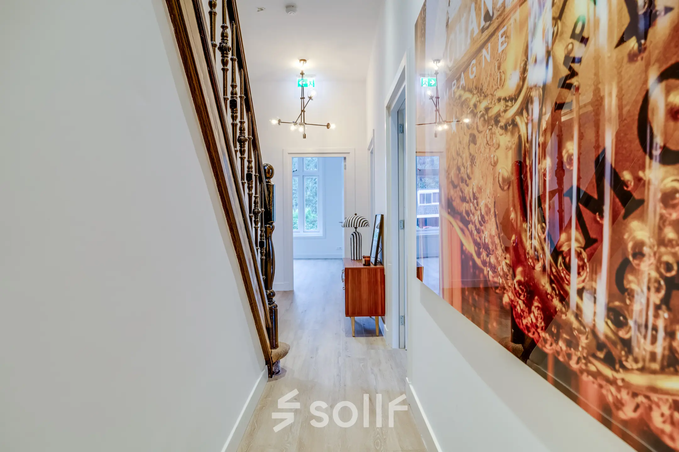 Entree van een kantoorpand aan de Graaf Florislaan 40 in Hilversum met kunst aan de muur en een moderne houten vloer.