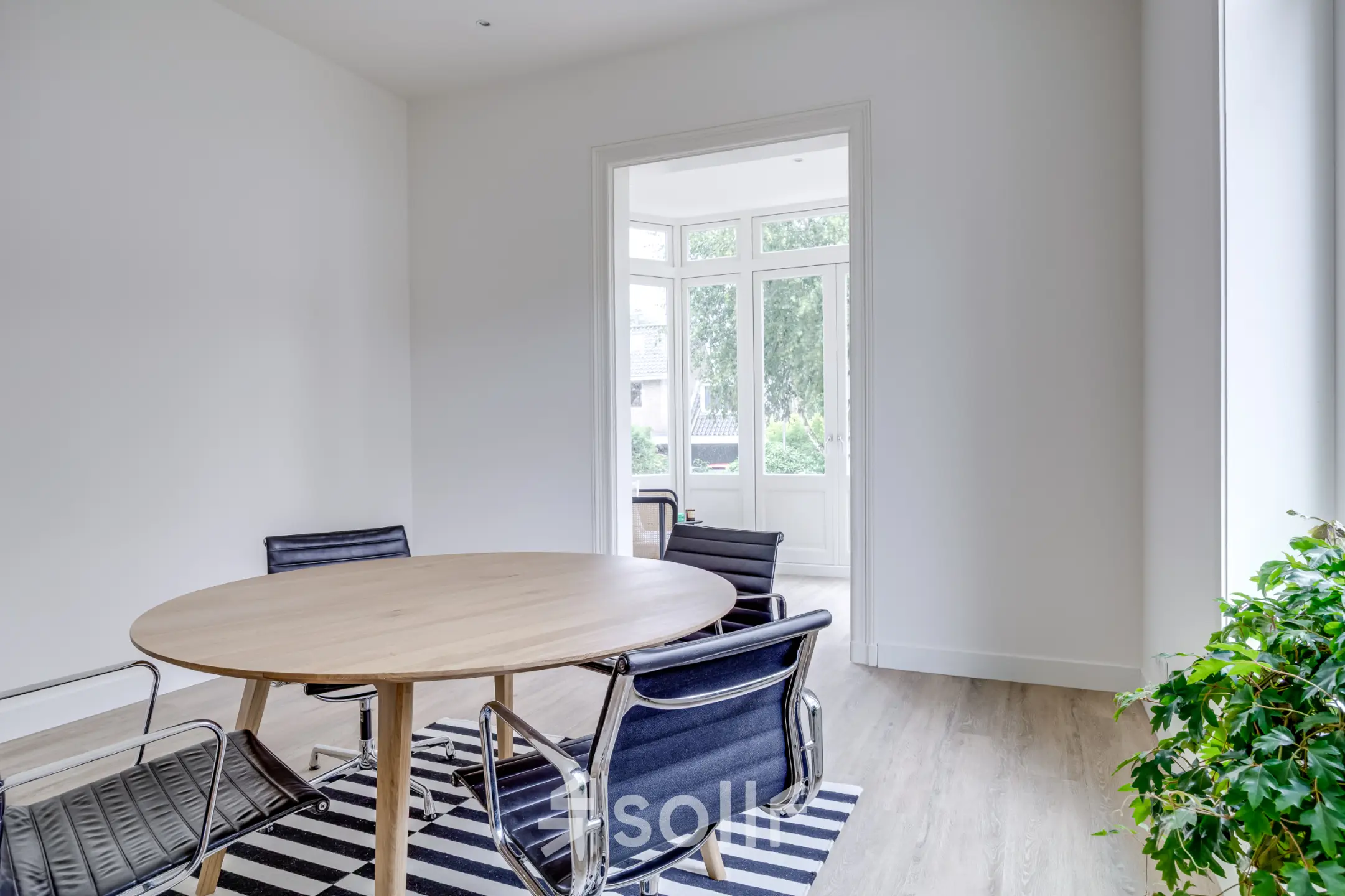 Lichte kantoorruimte op Graaf Florislaan 40, Hilversum met houten tafel en stoelen, geschikt voor zakelijke activiteiten zoals vergaderingen.