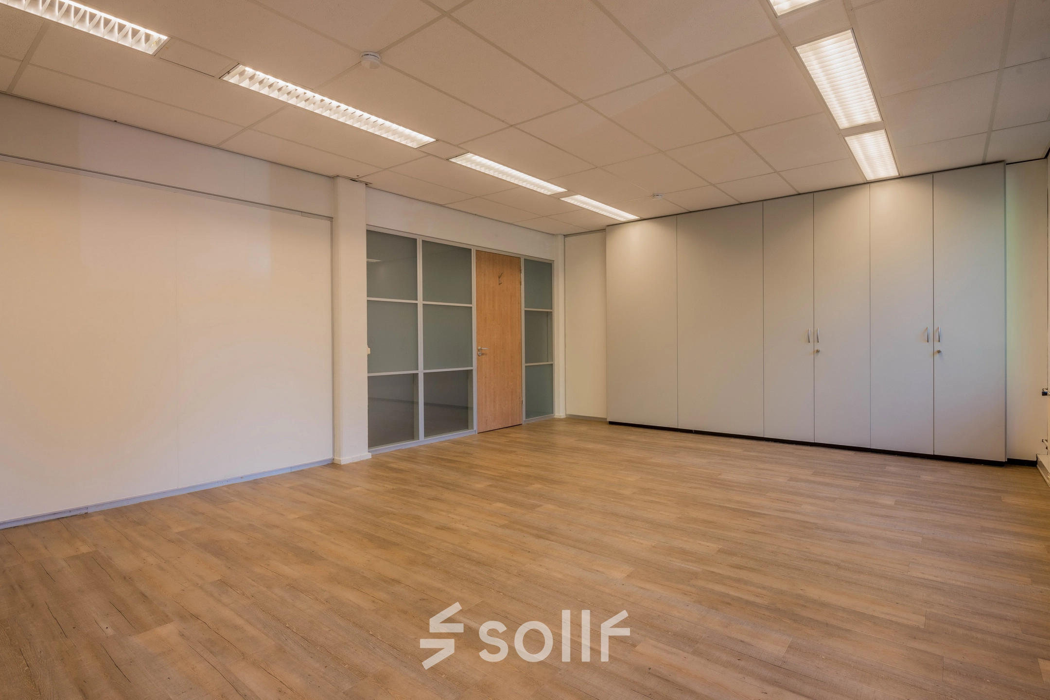 Lege kantoorruimte in het kantoorpand aan de Mozartlaan 25, Hilversum, te huren met een laminaatvloer en inbouwkasten.