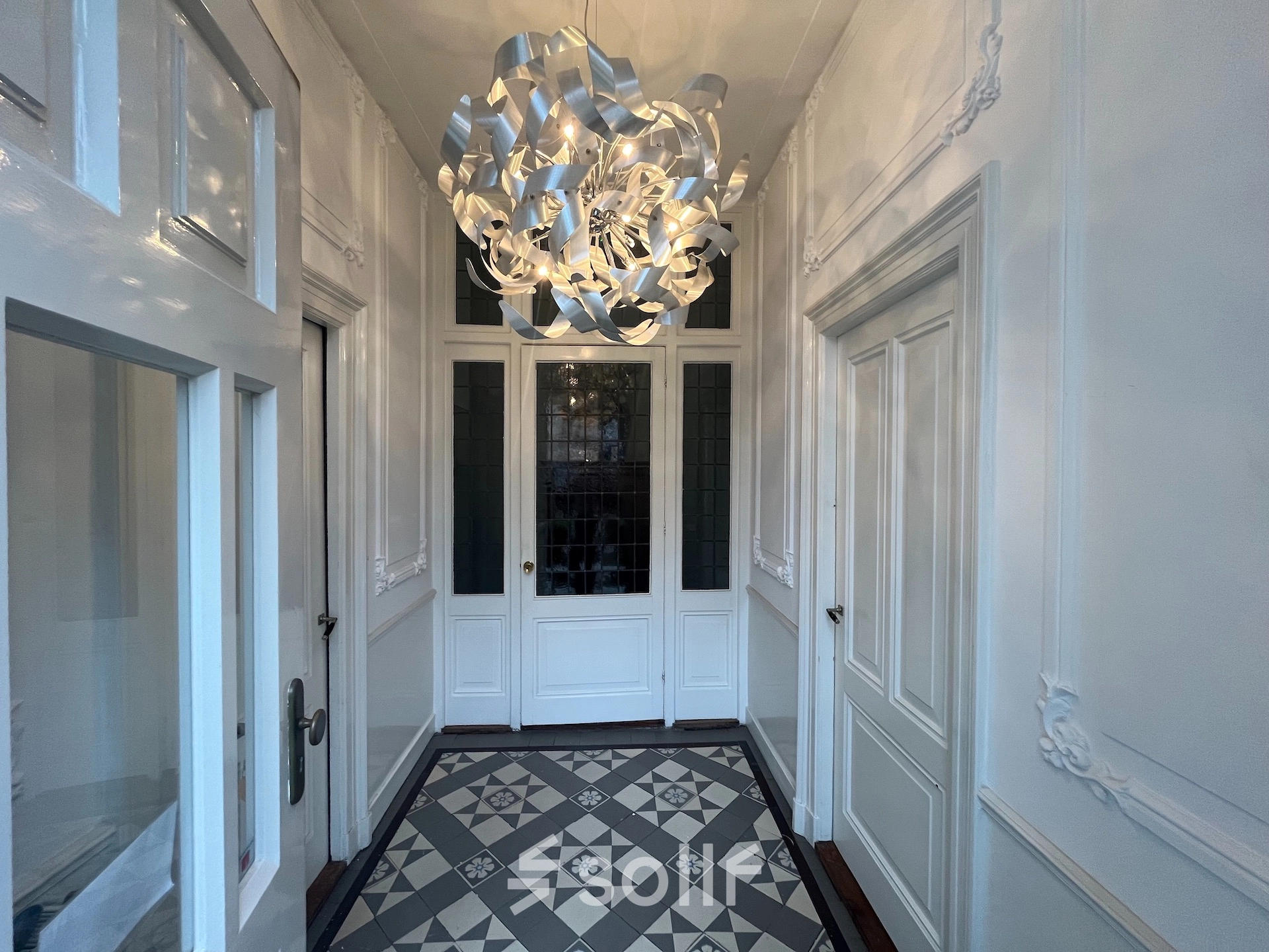 Ingang van kantoorpand op Oude Enghweg 8, Hilversum met stijlvolle betegelde vloer en kunstzinnige lamp.