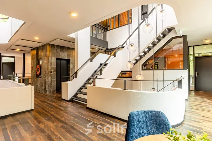 Modern kantoorpand op Steijnlaan 16, Hilversum met een stijlvolle houten vloer en open trap. Ideaal voor het huren van kantoorruimte.