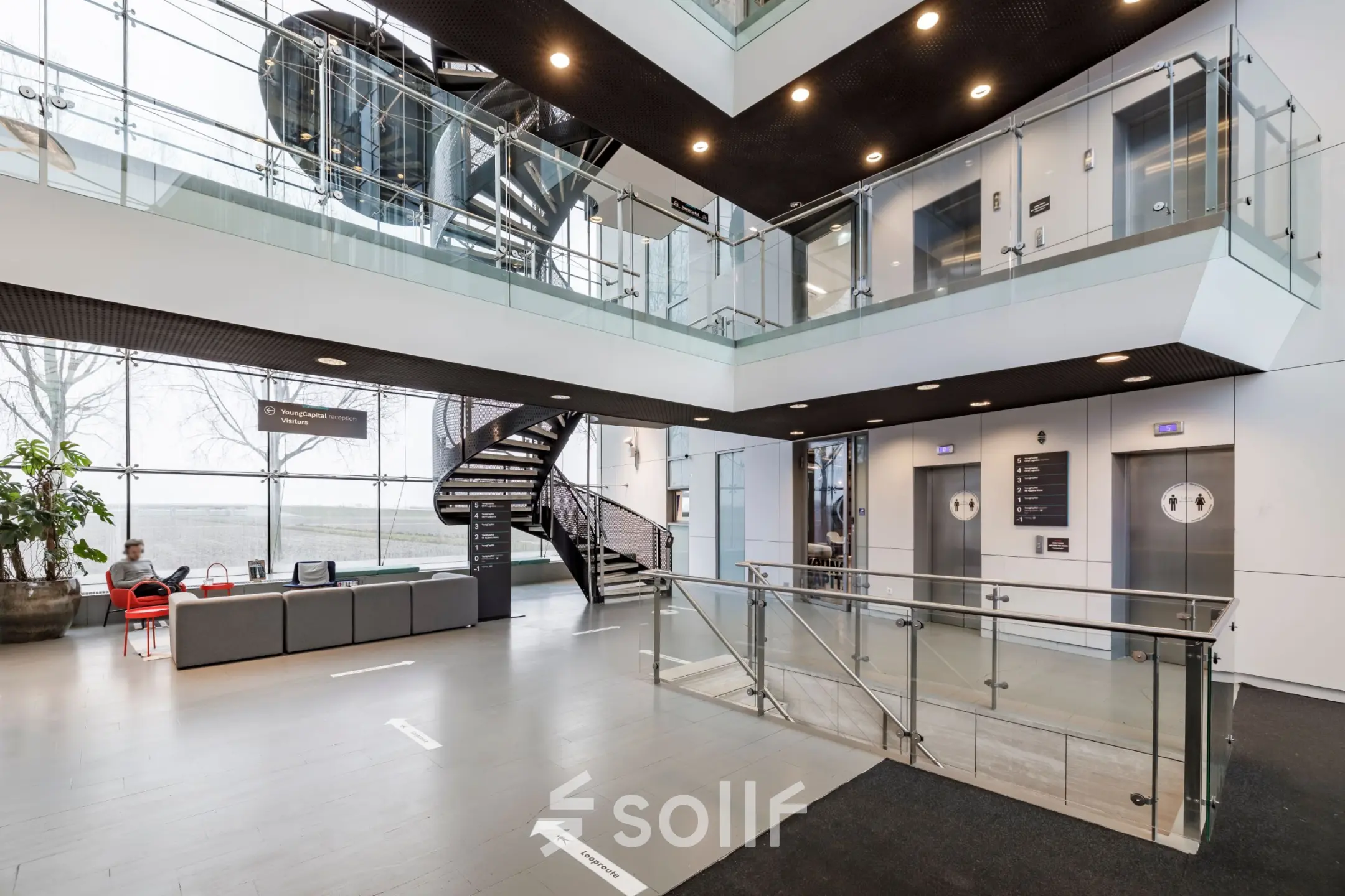 Moderne entree van een kantoorpand op Siriusdreef 16 in Hoofddorp met loungeset en liften. Perfect voor bedrijven die kantoorruimte willen huren.