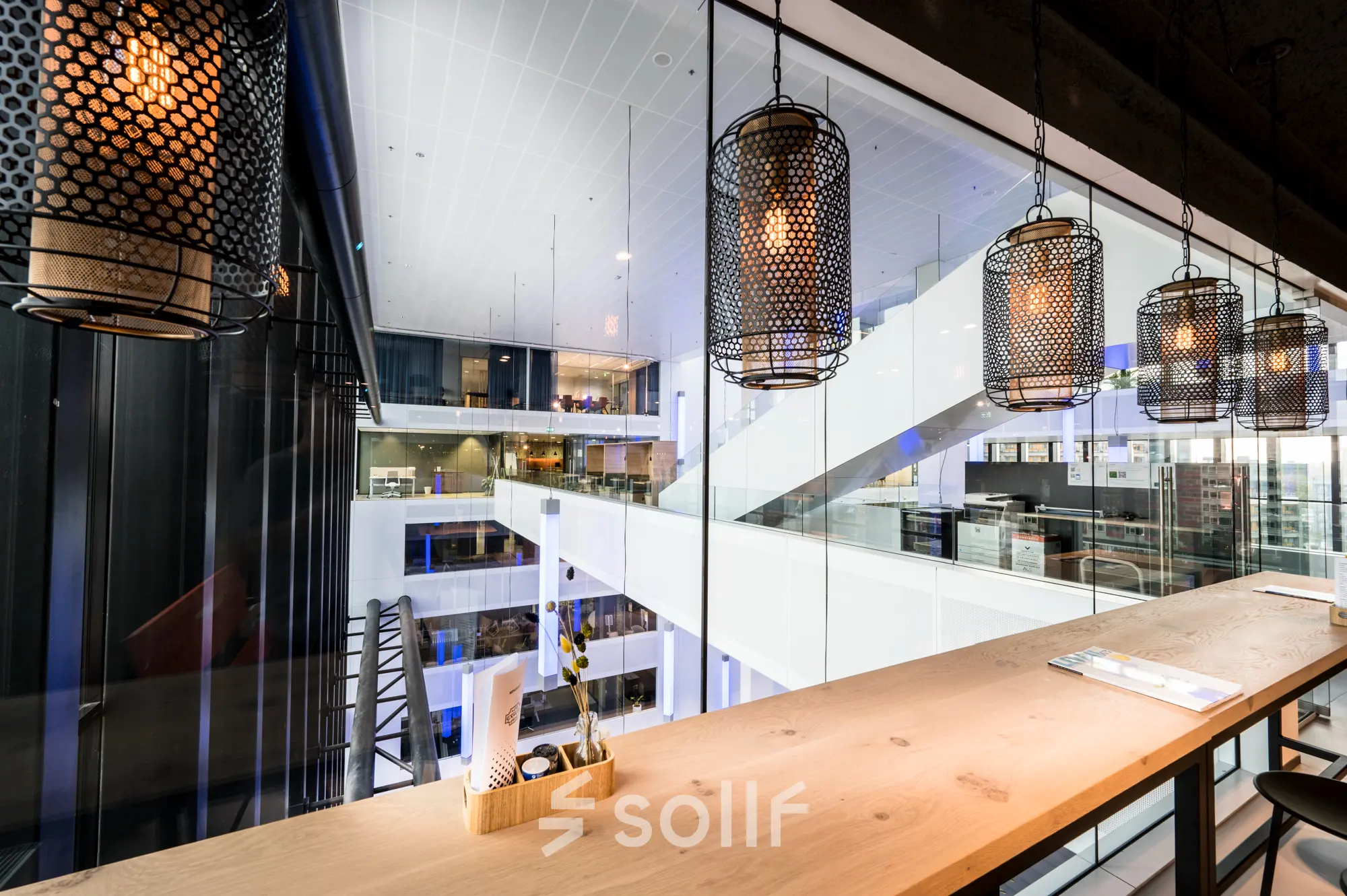 Moderne kantoorruimte huren aan Bargelaan 200 in Leiden, met zicht op een atrium en designverlichting, ideaal voor flexibele werkplekken.