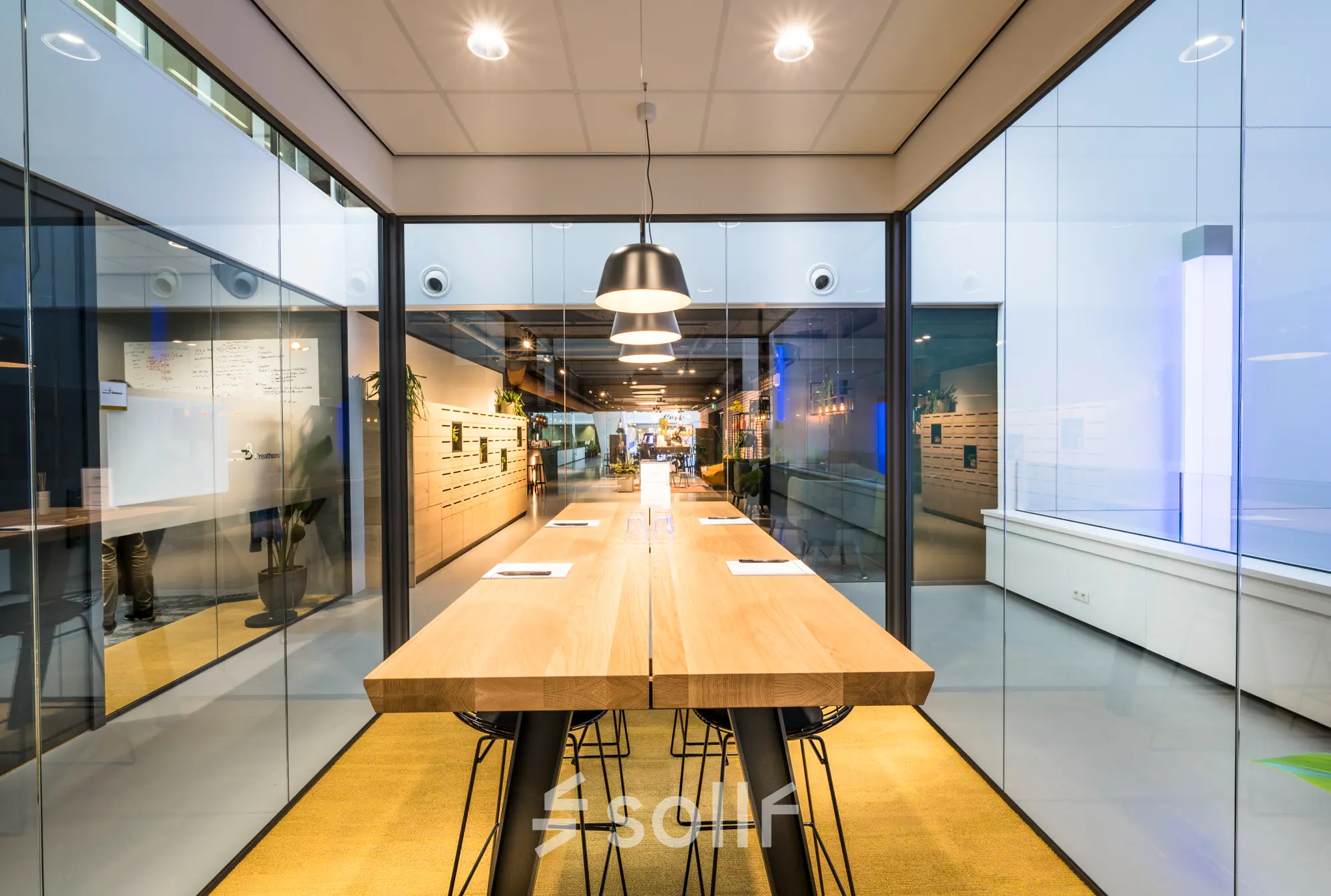 Moderne vergaderruimte in kantoorpand op Bargelaan 200, Leiden, met lange houten tafel en designstoelen, ideaal voor kantoorruimte huren.
