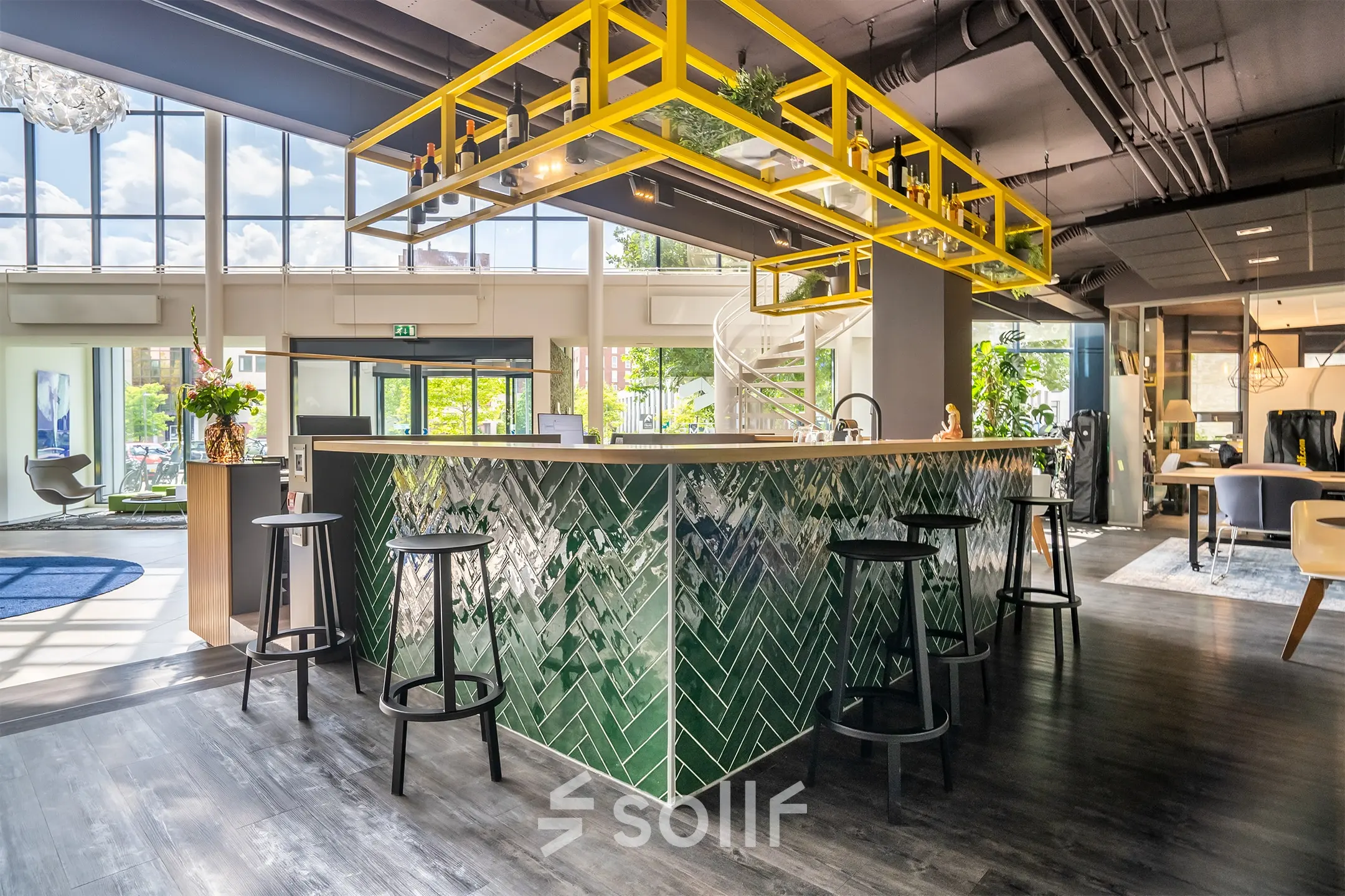 Moderne kantoorruimte op Kanaalpark 140 in Leiden met een stijlvolle bar, groene tegels en gele accenten. Ruim, met veel natuurlijk licht en zitmogelijkheden.