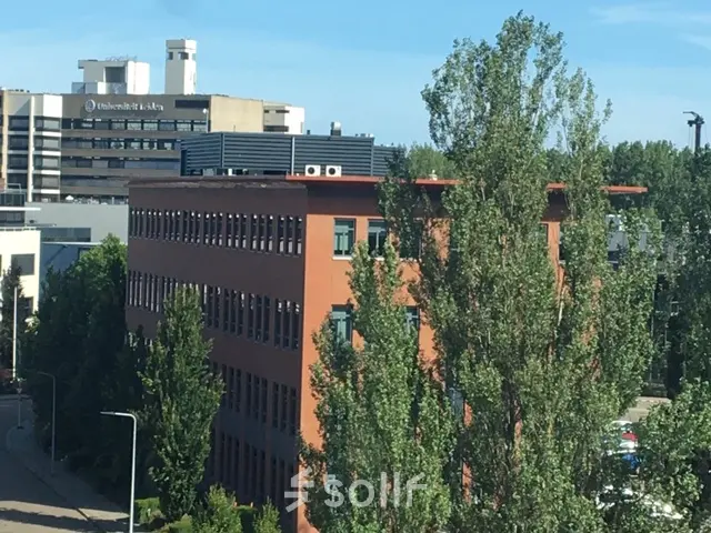 Modern kantoorpand aan de Mendelweg 30 in Leiden met veel ramen en omringend groen.