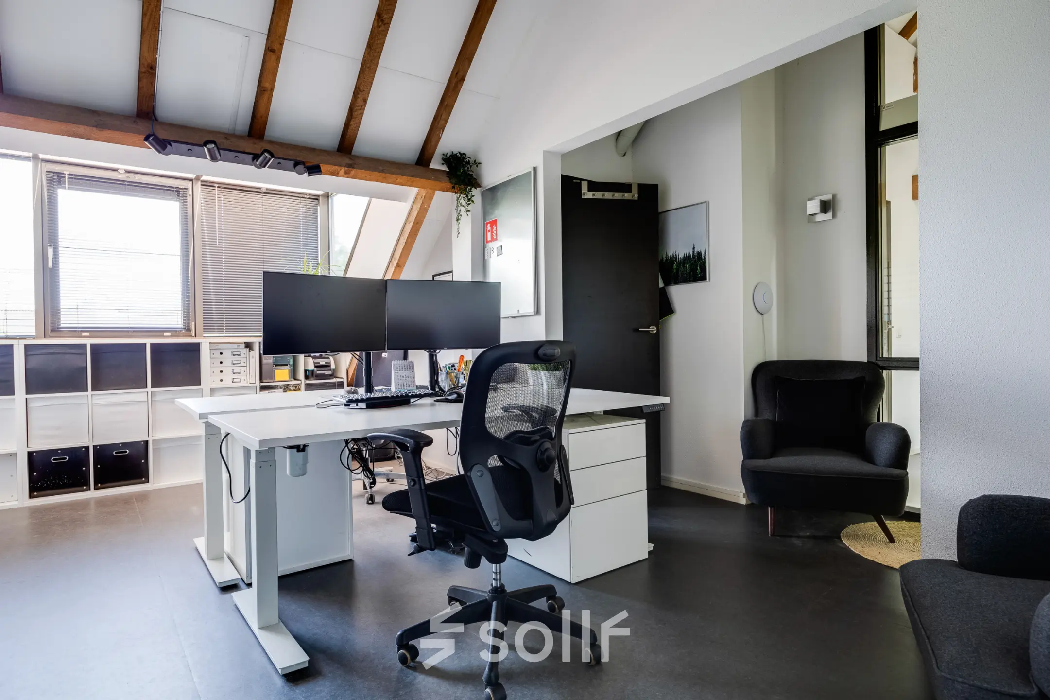 Lichte kantoorruimte te huur in Leusden met houten balken en moderne werkplekken. Groot bureau met dubbele monitor. Gezellige sfeer voor productief werk in kantoorpand Hamersveldseweg 120.