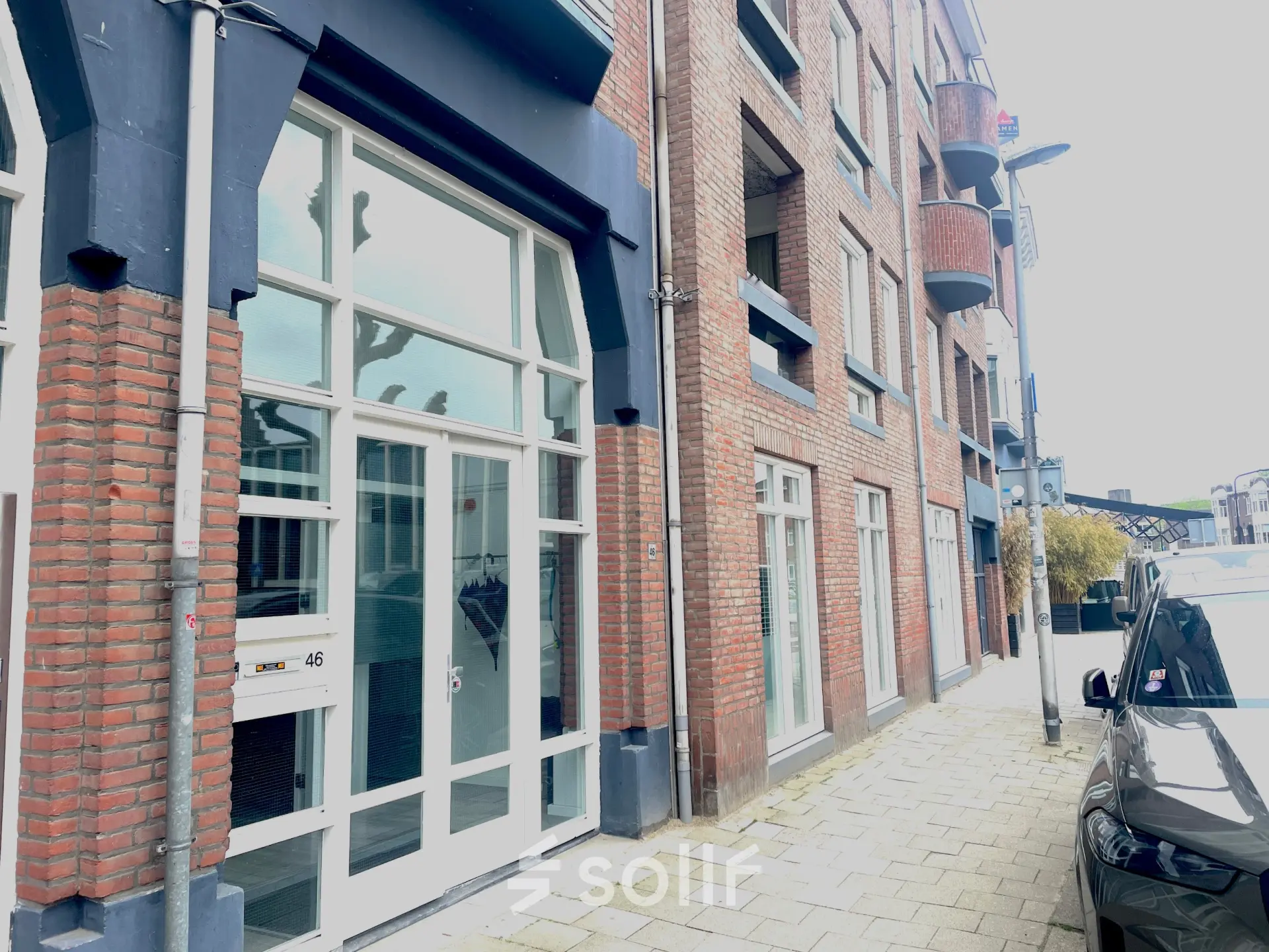 Buitenzijde van het kantoorpand op Wilhelminasingel 44-46 in Maastricht, met grote ramen en een rood bakstenen gevel. Ideaal voor kantoorruimte huren.