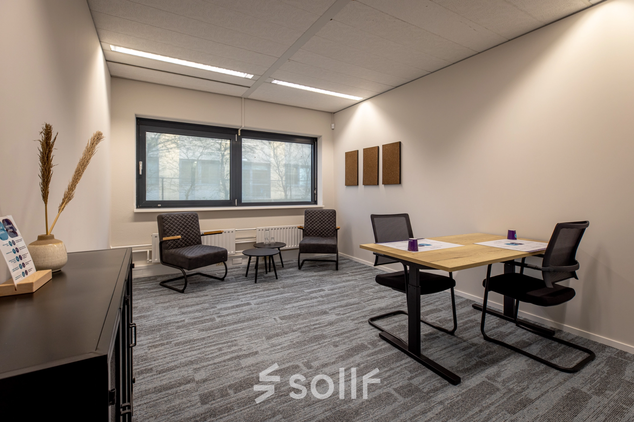 Gezellige kantoorruimte huren op Gooimeer 1 in Naarden, met twee bureaus, comfortabele stoelen en raam met veel daglicht.