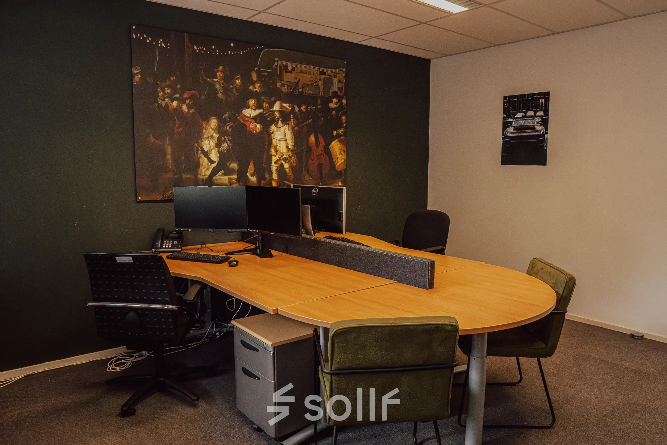Kantoorruimte huren op Abdis van Thornstraat 74 in Oosterhout Nb met een grote houten tafel, meerdere stoelen en computers, omringd door kunstwerken aan de muur in een professioneel kantoorpand.