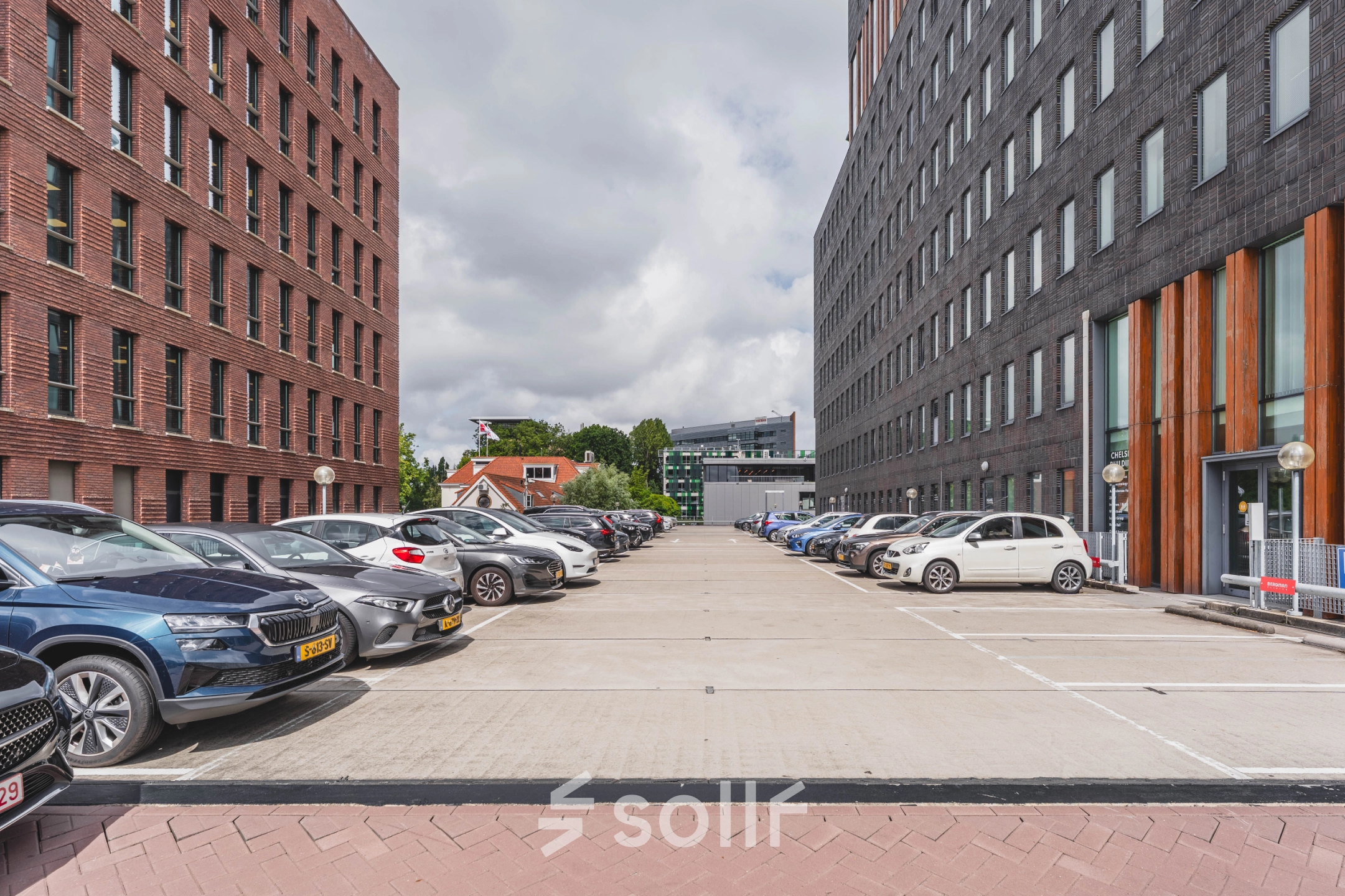 Parkeerplaats voor het kantoorpand op Laan van Zuid Hoorn 70, Rijswijk, met diverse geparkeerde auto's en omringende kantoorgebouwen.