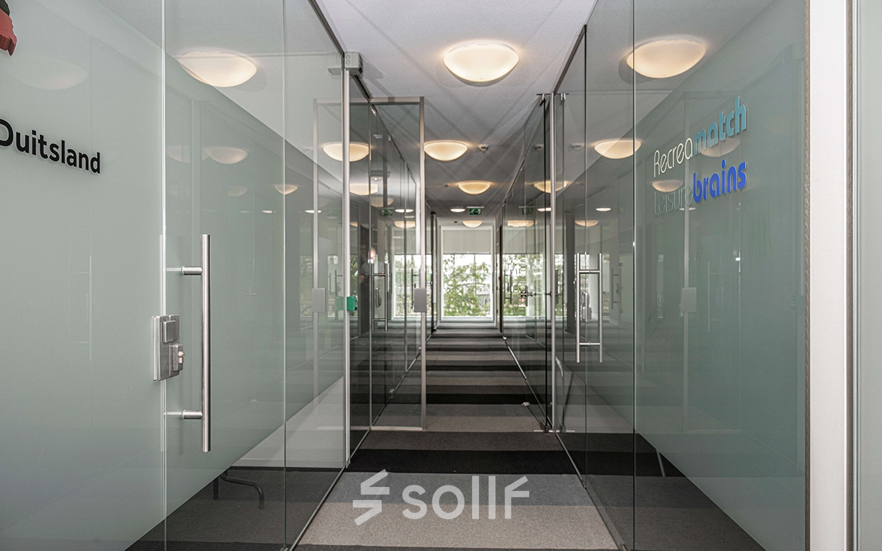 Transparante kantoorgang met glazen wanden in een kantoorpand op Boven de Wolfskuil 3, Roermond. Modern en strak ontwerp biedt mogelijkheden voor kantoorruimte huren.