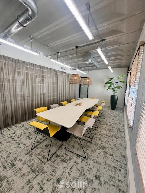Vergaderruimte in kantoorpand op Bahialaan 100, Rotterdam Brainpark, met lange tafel en moderne verlichting. Kantoorruimte huren met comfortabele stoelen en decoratieve planten.