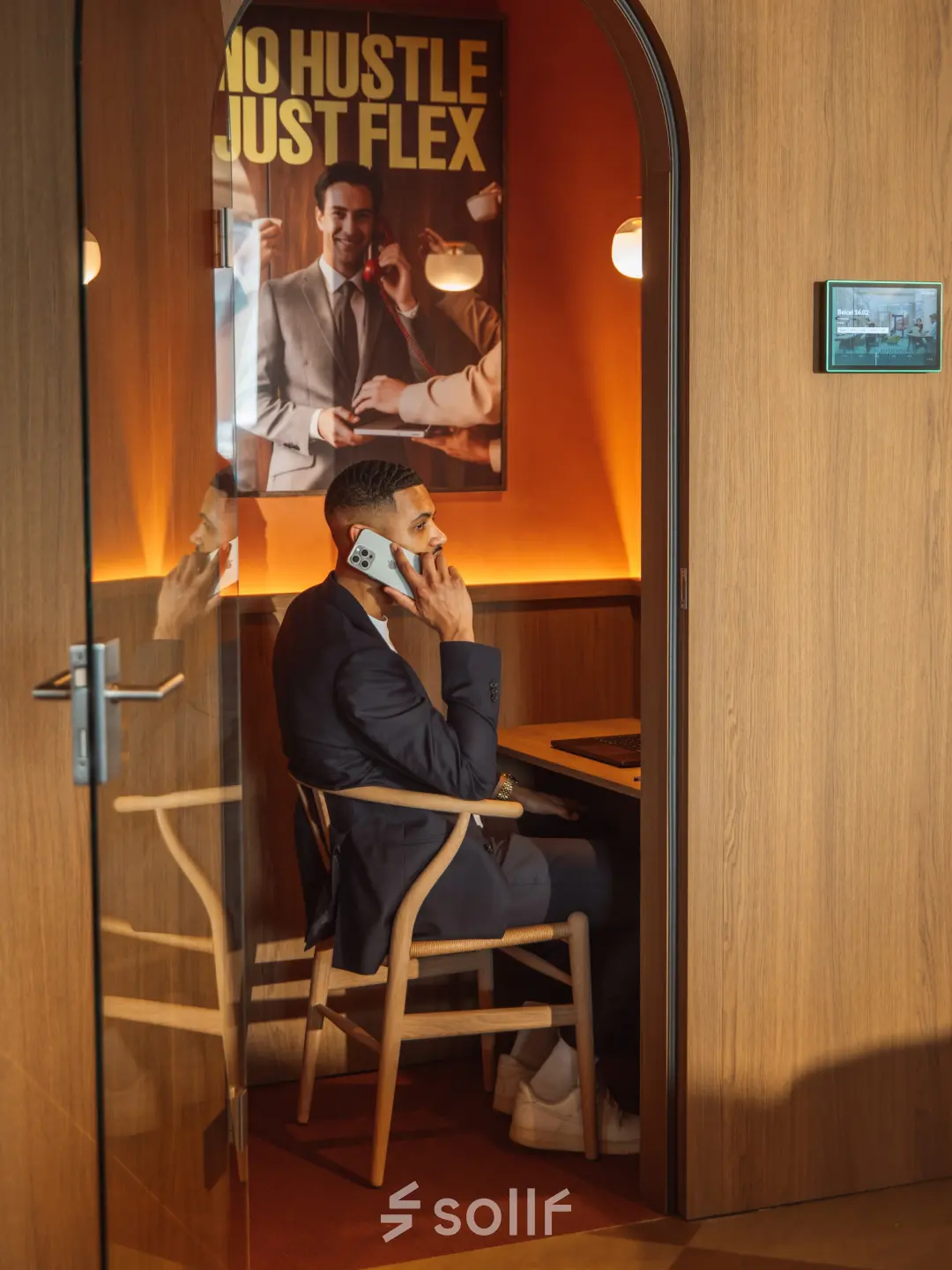 Zakelijke man telefoneert in modern ingerichte kantoorruimte op Coolsingel 139, Rotterdam Centrum. Huur deze stijlvolle werkplek voor comfortabele gesprekken en productieve momenten.