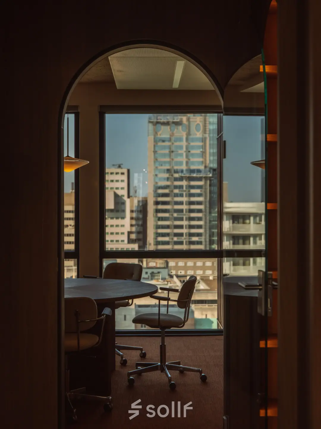 Lichte kantoorruimte met vergadertafel en stoelen, uitkijkend over de skyline van Rotterdam. Grote ramen bieden een prachtig uitzicht, ideaal om te huren op Coolsingel 139, Rotterdam Centrum.
