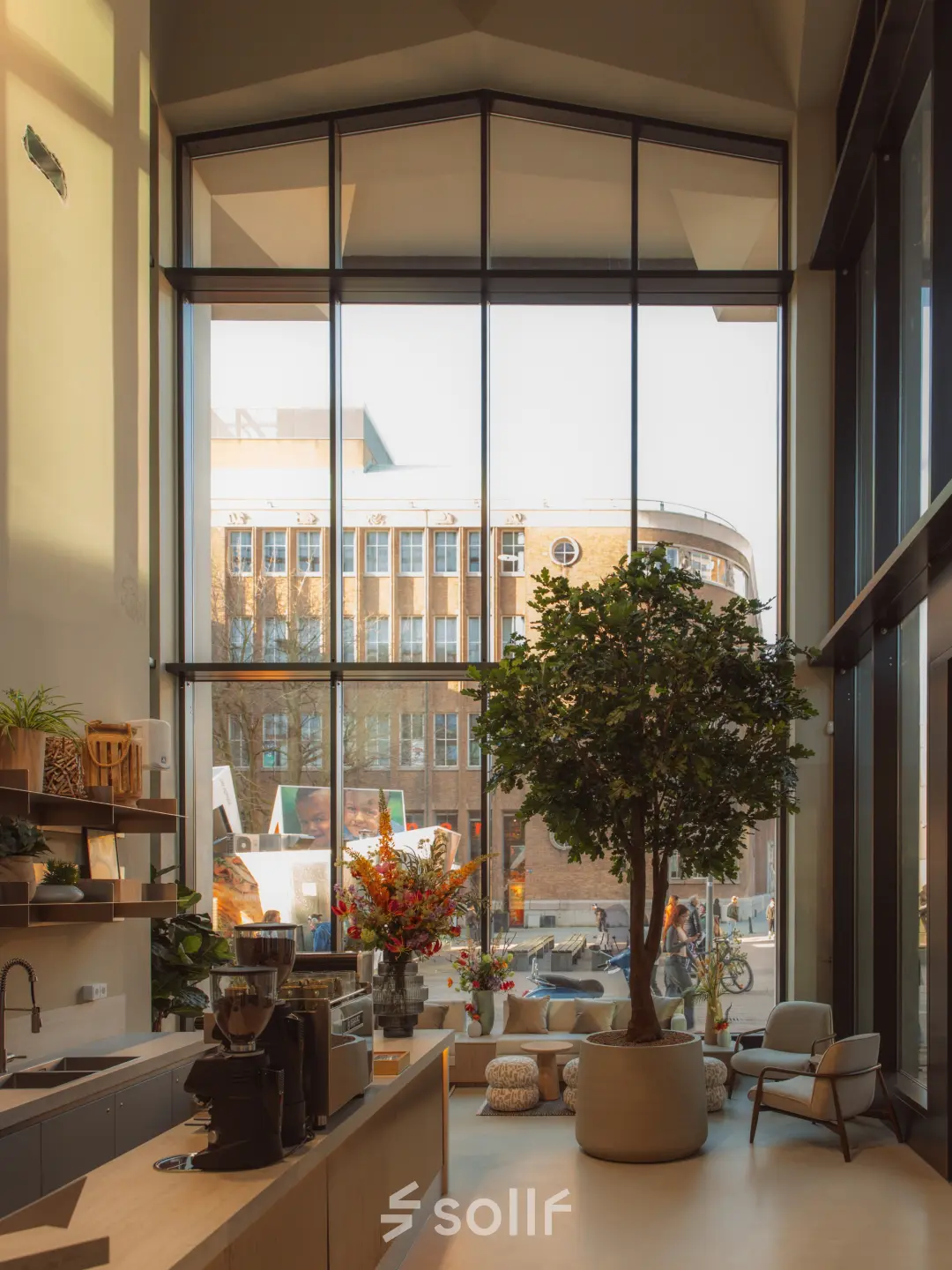 Moderne, lichte ruimte met hoge ramen aan de Coolsingel 139, ideaal voor kantoorruimte huren in Rotterdam Centrum. Groot raam met uitzicht en diverse planten en meubels aanwezig.