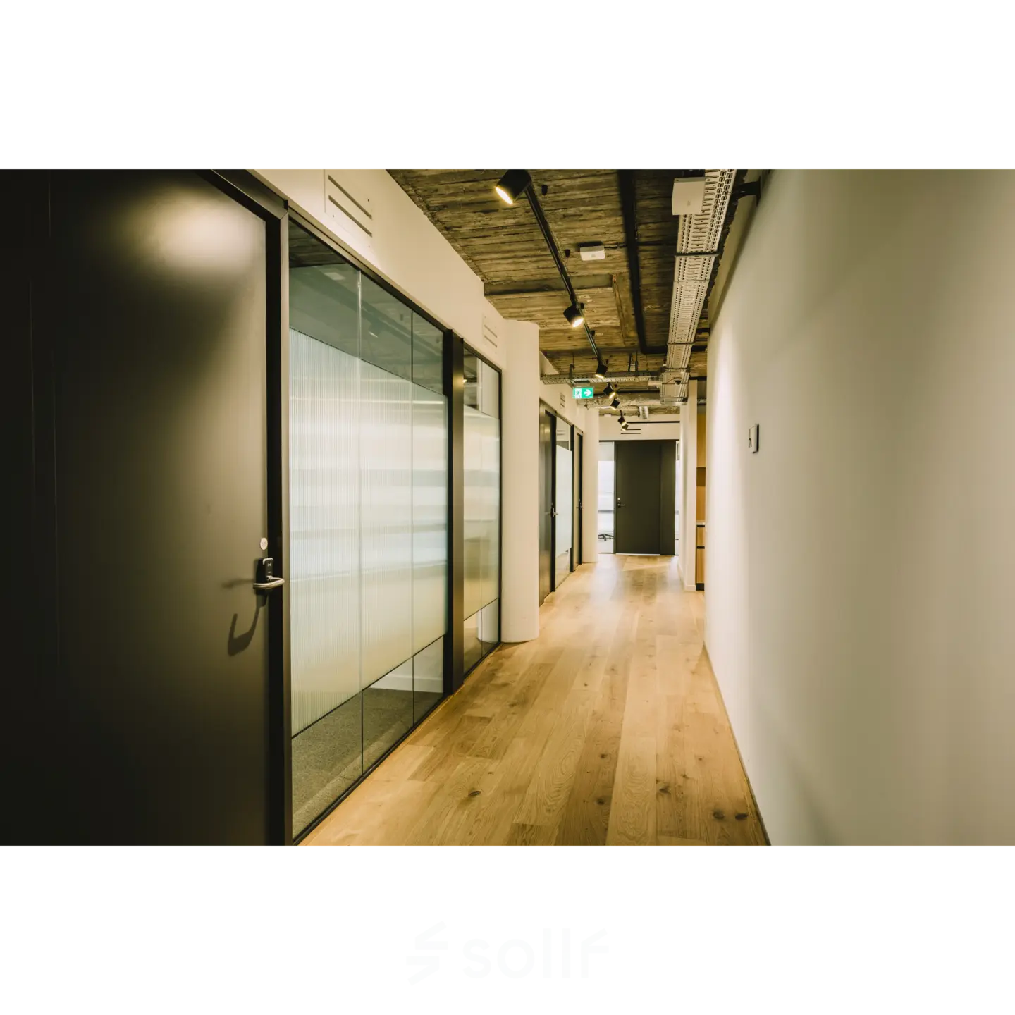 Lichte gang in kantoorpand aan de Coolsingel 65, Rotterdam Centrum, met houten vloer en glazen wanden. Ideaal voor kantoorruimte huren met moderne uitstraling.