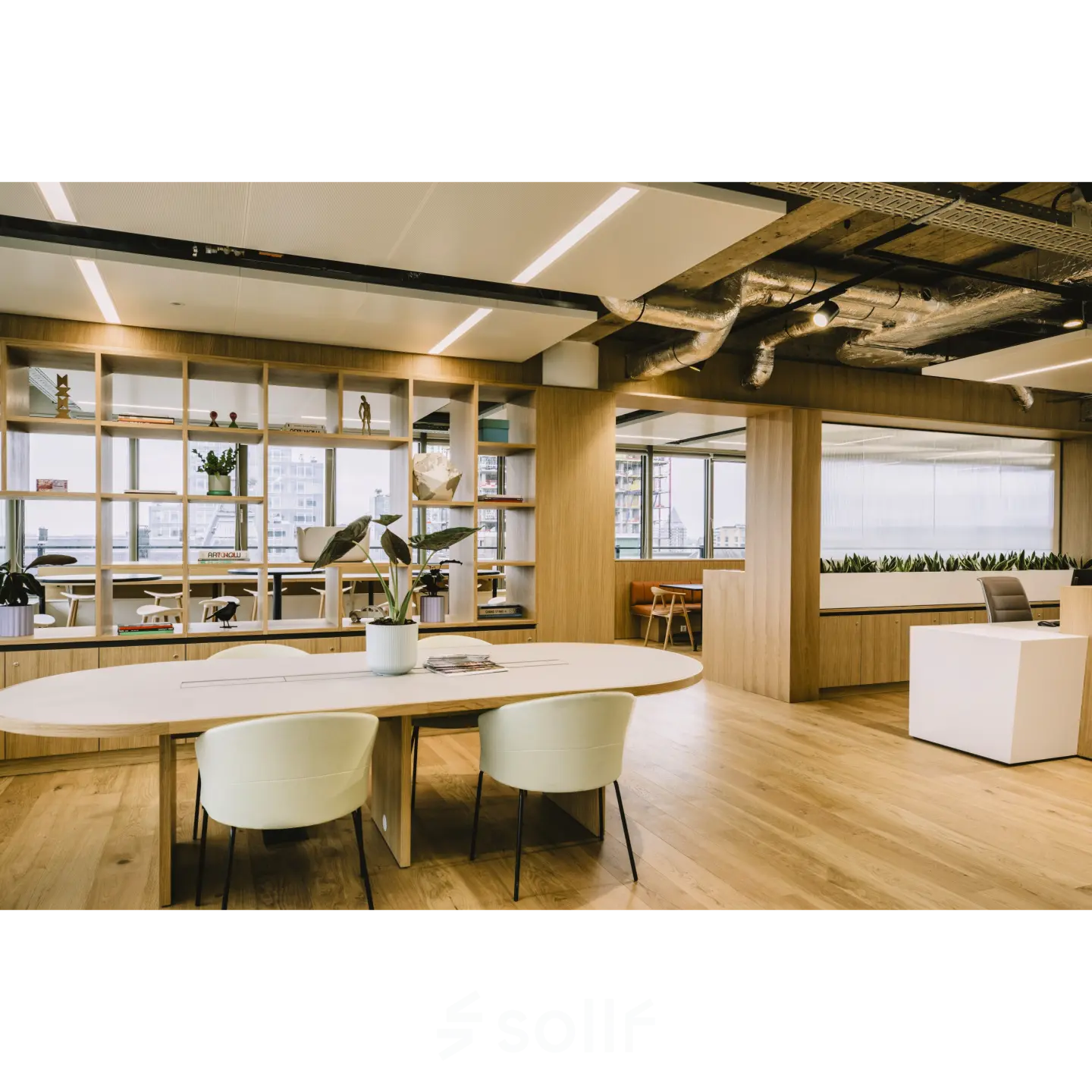 Moderne kantoorruimte huren op Coolsingel 65, Rotterdam Centrum. Lichte houten vloeren, houten scheidingswanden en designmeubilair met een open werkruimte. Groene planten zorgen voor een frisse sfeer in het kantoorpand.