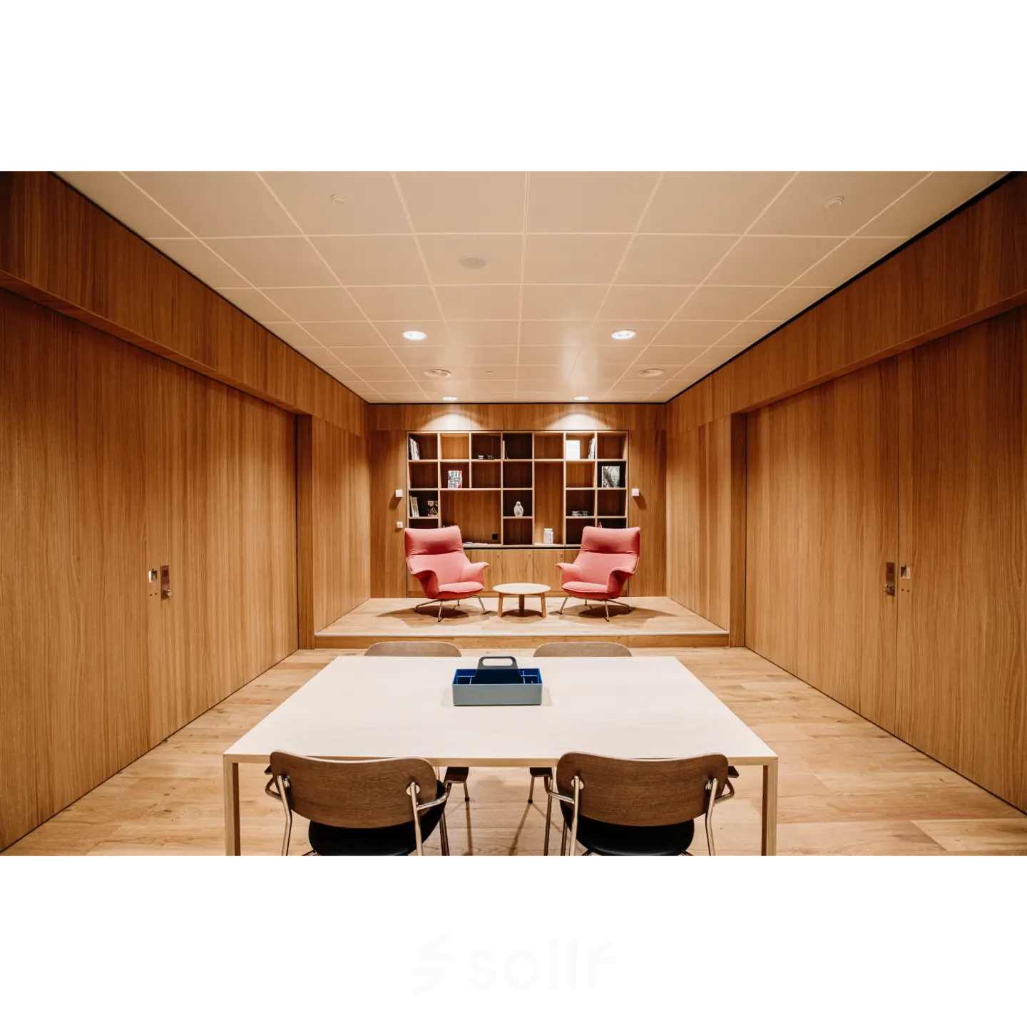 Moderne kantoorpand op Hoogstraat 185 in Rotterdam Centrum met houten wanden, een tafel met stoelen en comfortabele fauteuils. Ideale plek voor kantoorruimte huren.