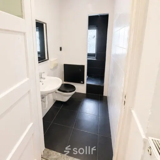 Moderne kantoorruimte huren bij kantoorpand Mauritsweg 33 A01, Rotterdam Centrum. Donkere tegels en wit sanitair typeren de ruimte. Ideaal voor huur als fris en functioneel kantoor.