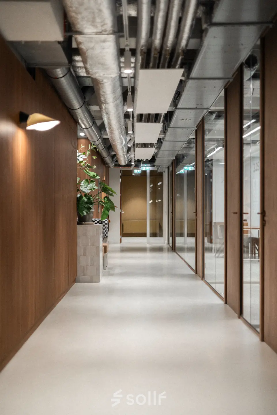 Moderne gang in een kantoorpand met houten panelen, zicht op vergaderruimtes. Ideale plek voor kantoorruimte huren in Rotterdam Centrum.